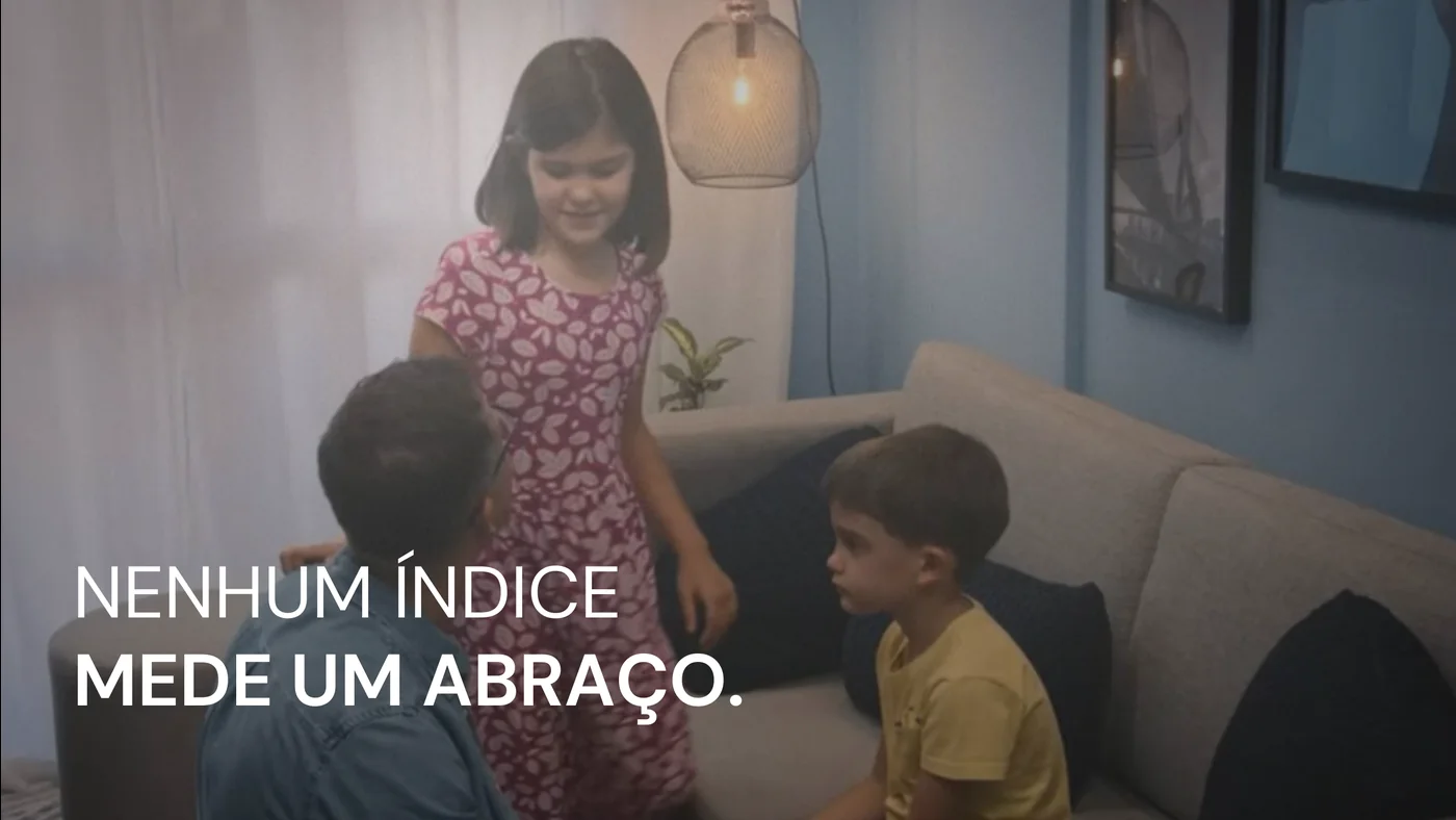 Crianças abraçando Rafael em uma sala, com a frase nenhum índice mede um abraço.